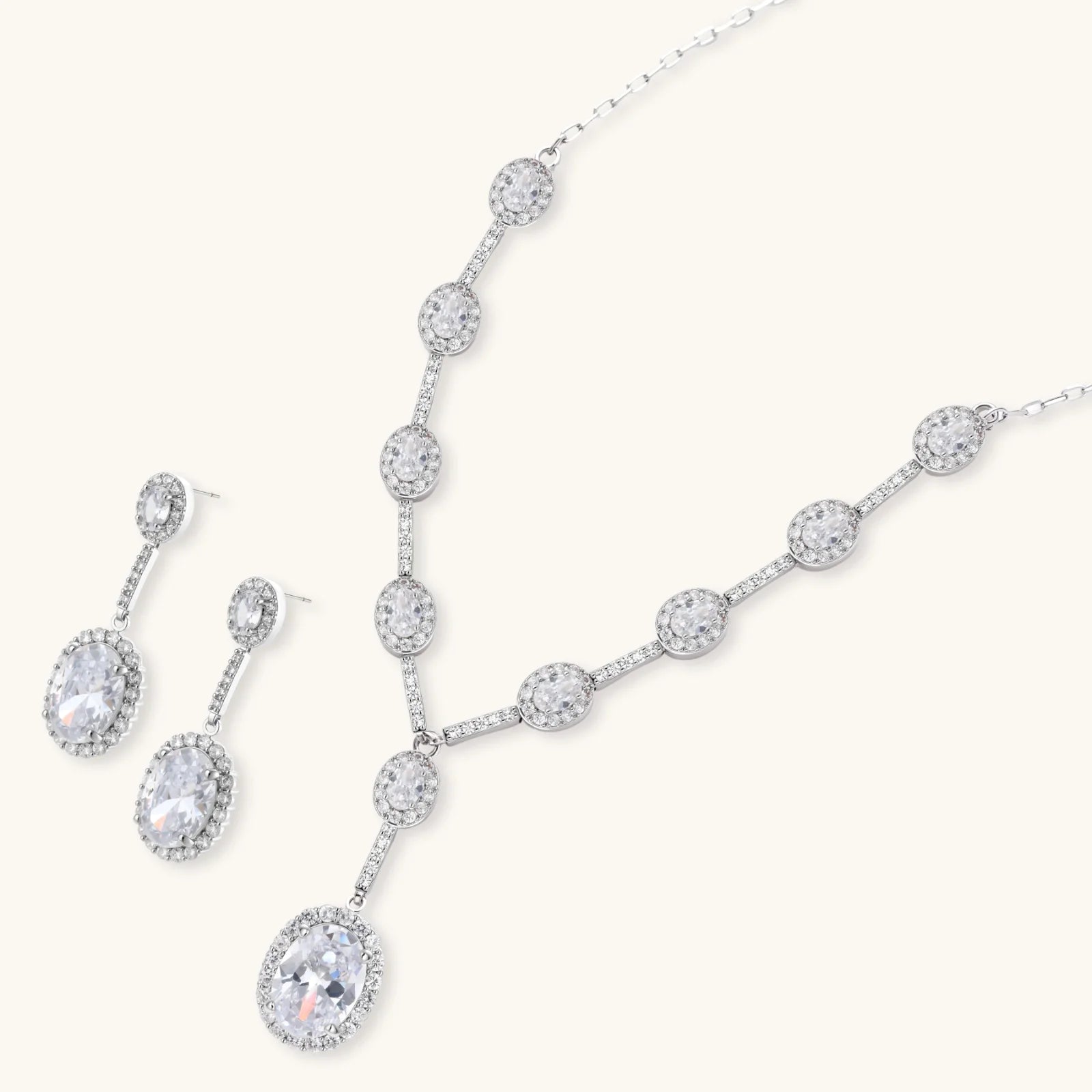 Elegant white gold plated jewelry set with oval cubic zirconia stones in halo settings, featuring Y-necklace and drop earrings.