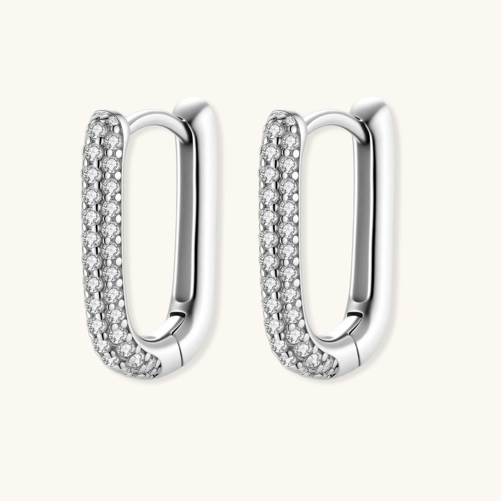 Close-up of small sterling silver huggie hoops completely covered in sparkling clear crystals with hinged closure