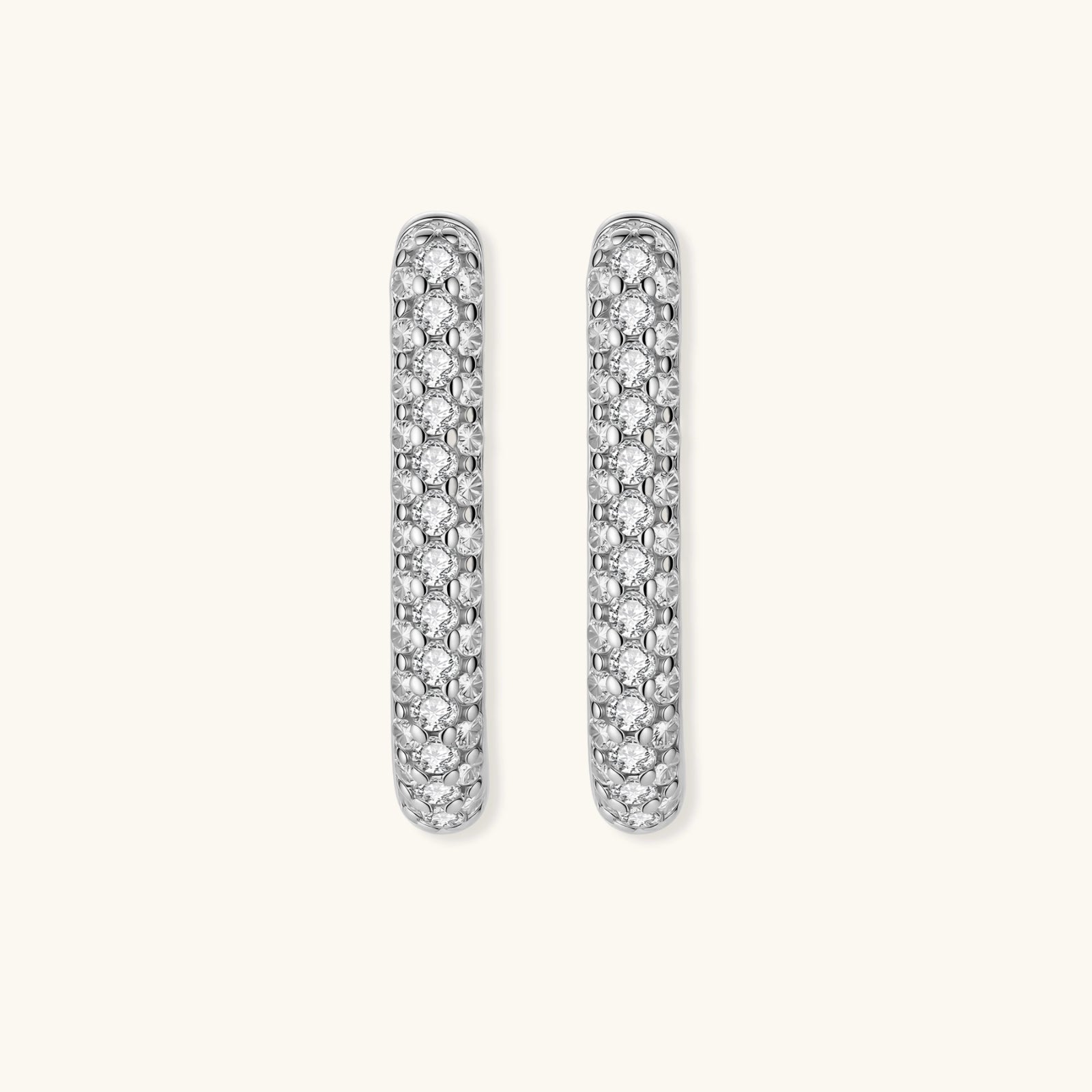 Close-up of small sterling silver huggie hoops completely covered in sparkling clear crystals with hinged closure